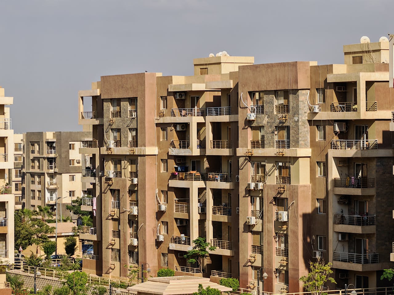Aerial view of a modern urban apartment complex with beige and brown facades.